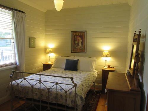 - une chambre avec un lit, 2 tables de nuit et 2 lampes dans l'établissement Nivani 1880's cottage, à Port Fairy