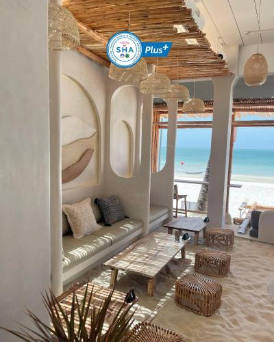 a living room with a couch and a view of the beach at Phangan Bayshore Resort Koh Phangan in Haad Rin