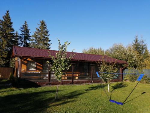 ein Blockhaus mit zwei Bäumen im Hof in der Unterkunft Ezüst fenyő vendégház in Borzont