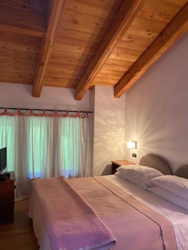 - une chambre avec deux lits et des plafonds en bois dans l'établissement Chalet Delle Rose, à Santi di Daone