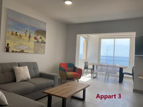 un salon avec un canapé et une table dans l'établissement Appartements résidence Harmonie vue mer, à Porticcio