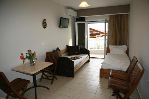 a living room with a couch and a bed and a table at Atlon Hotel in Paralia Vrachou