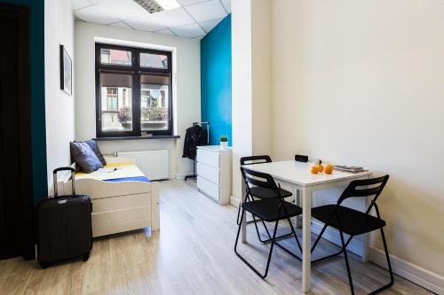 a room with a desk and a bed and a table at Hello Hostel & Apartments in Bielsko-Biala