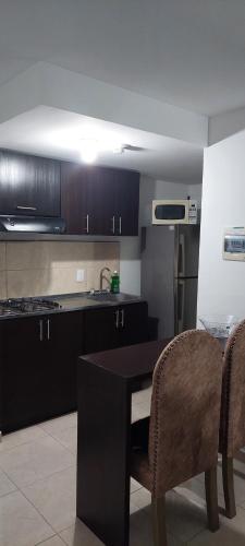 a kitchen with a black table and two chairs at Arturo Apartamento Con hermosa vista y piscina in Armenia