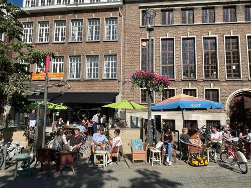 a group of people sitting at tables in front of a building at Maju in Antwerp