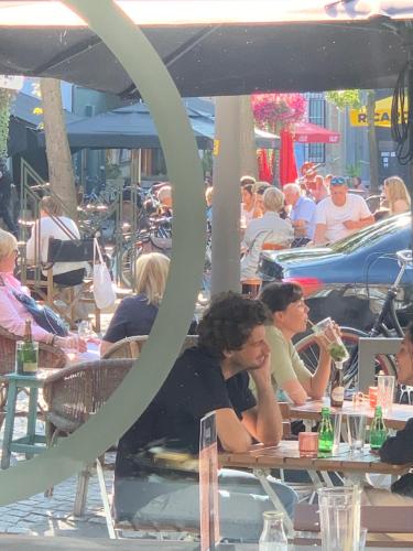 a group of people sitting at tables in an outdoor restaurant at Maju in Antwerp