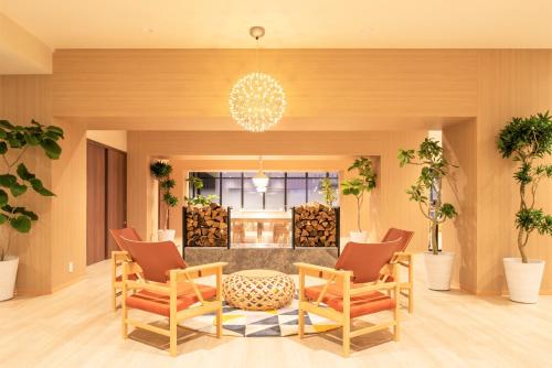 a lobby with chairs and a table and a fire place at HOTEL AMANEK Asahikawa in Asahikawa