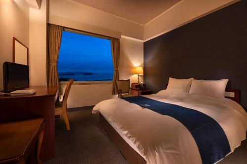 Kurashiki Seaside Hotel في كوراشيكي: غرفه فندقيه بسرير ونافذه