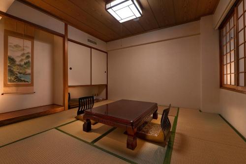 een kamer met een tafel en stoelen en een raam bij Kurashiki Seaside Hotel in Kurashiki