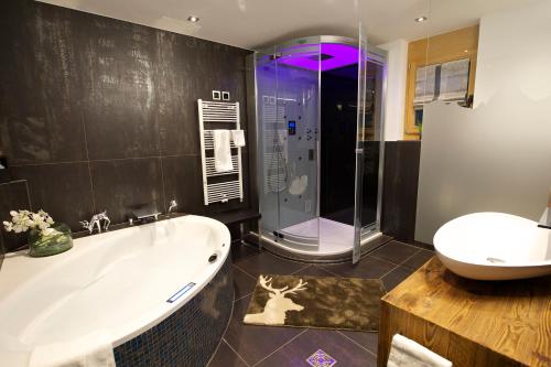 W łazience znajduje się wanna, prysznic i umywalka. w obiekcie Chalet Matterland w mieście Zermatt
