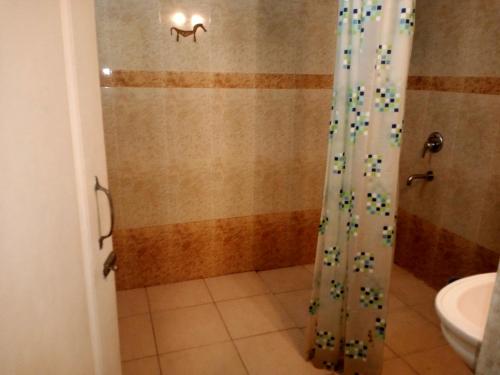 a shower with a glass door in a bathroom at River side apartment in Cavelossim