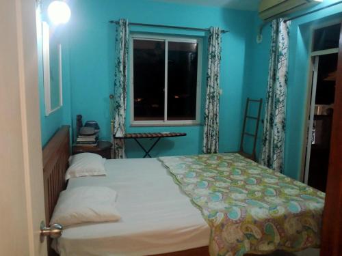 una camera blu con un letto e una finestra di River side apartment a Cavelossim