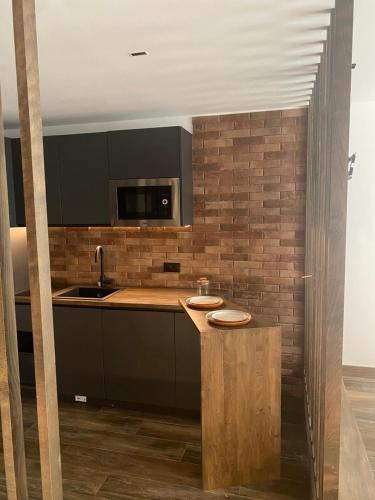 a kitchen with black cabinets and a counter with a sink at Botavara Madrid con Parking incluido in Madrid