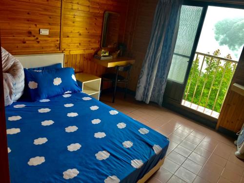 a bedroom with a blue bed with white clouds on it at Junlin Holiday Farm in Hualing
