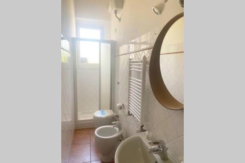 a bathroom with a sink and a toilet and a mirror at Bronzino Flexyrent Renewed - AC - WiFi in Florence