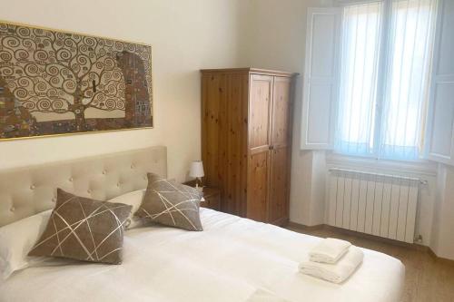 a bedroom with a large white bed with two pillows at Bronzino Flexyrent Renewed - AC - WiFi in Florence