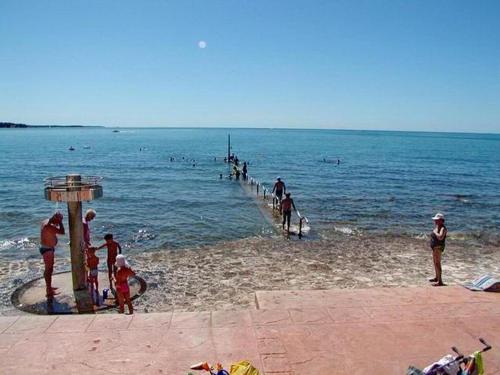 a group of people on a beach near the water at Apartman Ema in Novigrad Istria