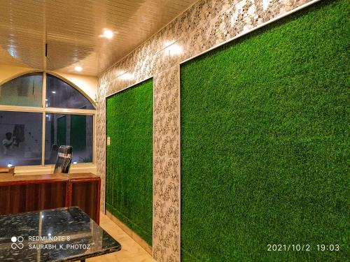 a green wall in a room with a window at Hotel Jungle Palace Resort in Umariā