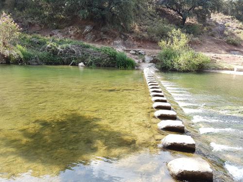 una fila de rocas en el agua junto a un río en Villa Cristina, en Benaoján