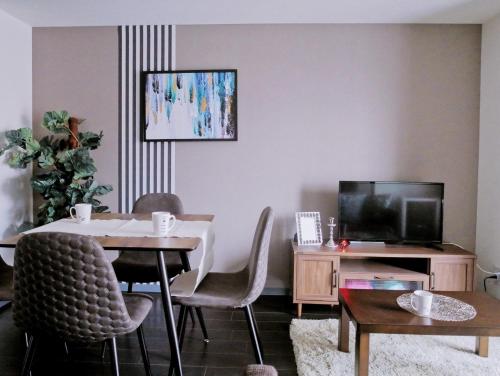 a living room with a table and a tv at Suncourt Hongo Dori Garden Hills / Vacation STAY 7620 in Sapporo