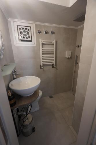 a bathroom with a white sink and a toilet at "Del Sole" Spa Apartment in Serres