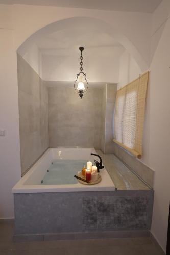a bath tub with candles and two candles on a tray at "Del Sole" Spa Apartment in Serres