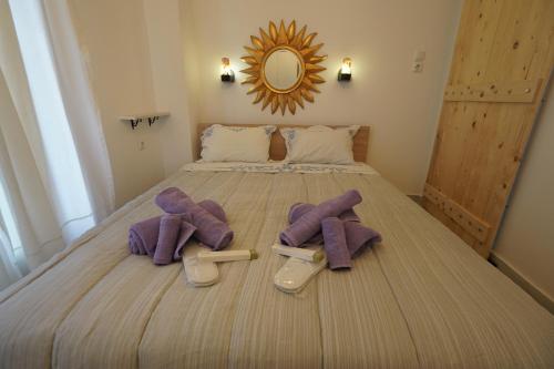 a bedroom with a bed with purple towels and slippers at "Del Sole" Spa Apartment in Serres