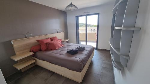 a bedroom with a bed with red pillows on it at Appartement neuf T2 centre de Porticcio in Porticcio