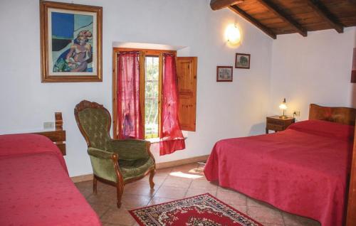 a bedroom with two beds and a chair and a window at Agriturismo Il Bardellino in Fivizzano