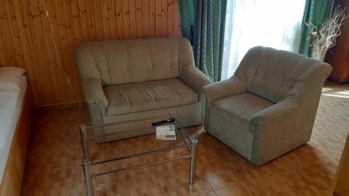 a living room with a couch and a chair at Penzión pri studničke Omastiná in Omastiná