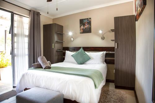 Un dormitorio con una cama grande y una ventana en Nahoon Eco Lodge on Mackenzie, en East London