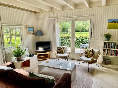 a living room with a couch and a tv at Gastenverblijf Oostdijk in Goedereede