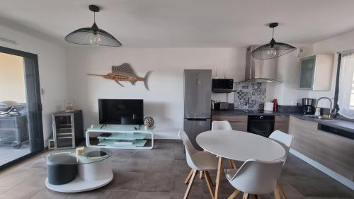 une cuisine avec une table et des chaises dans une pièce dans l'établissement Appartement neuf T2 centre de Porticcio, à Porticcio