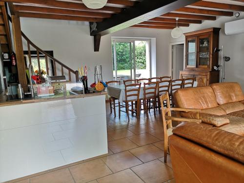 a kitchen and living room with a couch and a table at Les Fougères Du Lac in Saint-Plantaire