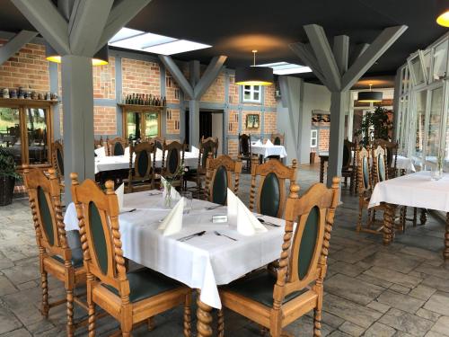 a dining room with white tables and chairs at Hotel Alte Fischerkate in Mödlich