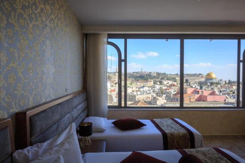 a hotel room with two beds and a view of the city at Hashimi Hotel in Jerusalem