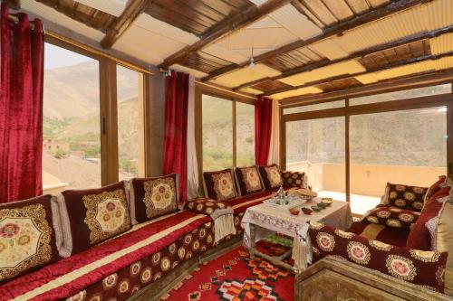 - un salon avec des canapés, une table et des fenêtres dans l'établissement Dar Chayma, à Imlil