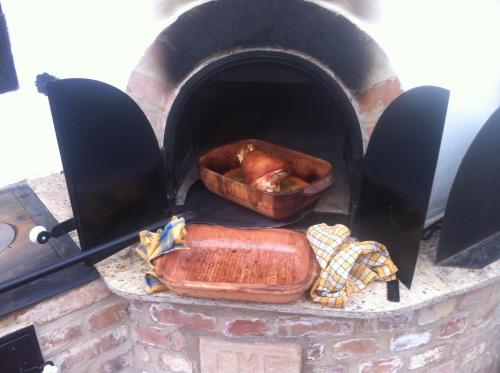 a oven with a pan of food in it at Bíbic Vendégházak in Nagybajom