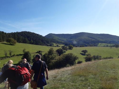 three people walking up a hill with backpacks at Penzión pri studničke Omastiná in Omastiná