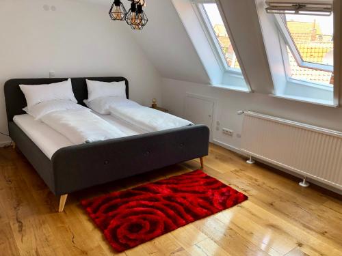 a large bed in a room with a red rug at Studio in der Celler Altstadt in Celle