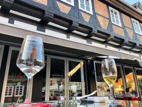 dos copas de vino sentadas en una mesa frente a un edificio en Studio in der Celler Altstadt en Celle