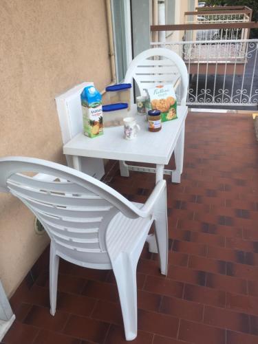 una mesa blanca y sillas con comida. en CASA MARE ANDORA, en Andora