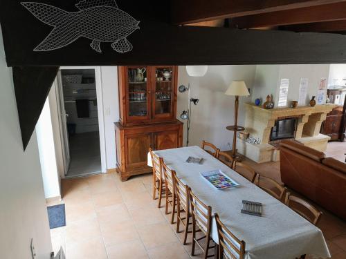 a dining room with a table and some chairs at Les Fougères Du Lac in Saint-Plantaire