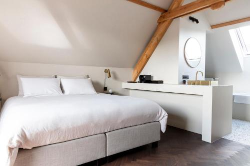 a bedroom with a white bed and a mirror at B'Guest Sleep & Retreat in Bruges