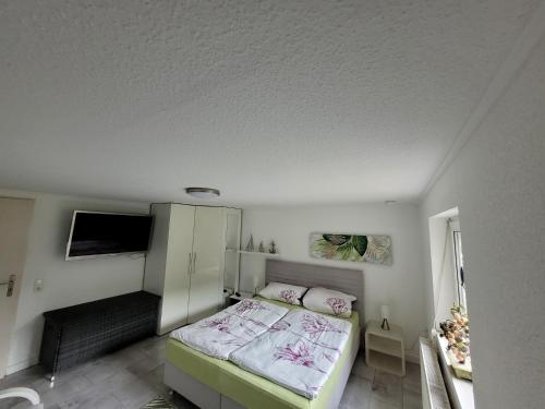 a small bedroom with a bed and a white ceiling at Fewo Moin Moin in Groß Petershagen