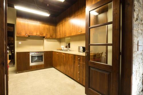 a kitchen with wooden cabinets and a door at Whitestone Mill in Pano Lefkara