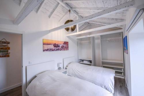 two beds in a room with white walls at Monchique Islet View House T2 in Faja Grande