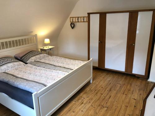 a bedroom with a white bed and a wooden floor at Haus Blum in Weisweil