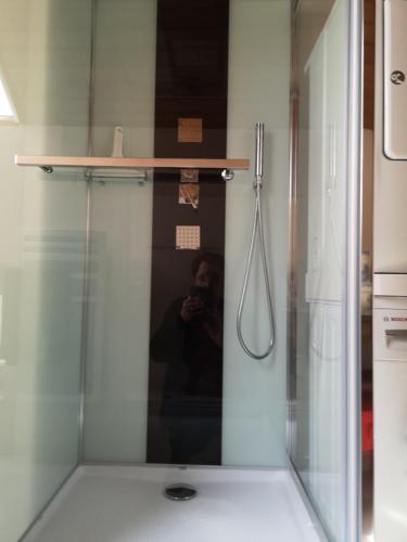 a man taking a picture of a shower in a bathroom at Les Fougères Du Lac in Saint-Plantaire