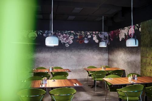 a restaurant with wooden tables and green chairs at Jaz in the City Vienna in Vienna